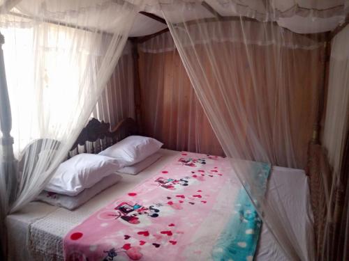 ein Schlafzimmer mit einem Bett mit Blumen darauf in der Unterkunft Maliga Inn in Gampola