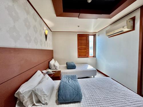 a small room with two beds and a window at Prada motel in Geoje 