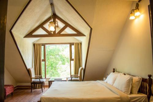 a room with a large bed and a window at The Whispering Inn Resort and Bar (An Exotic Vintage Beauty ) in Manāli