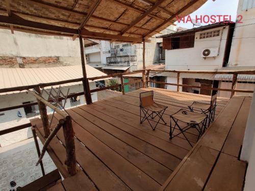 una terraza de madera con sillas en la parte superior de un edificio en Via Hostel Pakse, en Pakse