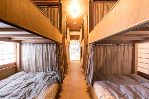 two bunk beds in a room with a hallway at Guest House Maru in Kashima
