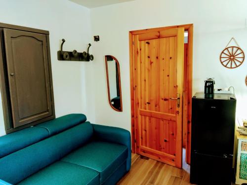 a living room with a blue couch and a door at Terra in Valledoria