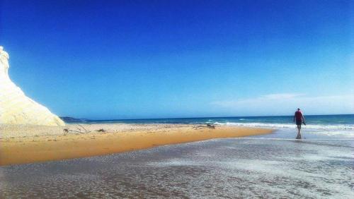 a man standing on a beach near the ocean at B&B Eraclea Minoa Mare in Eraclea Minoa