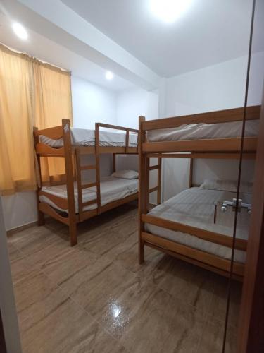 Habitación con 2 literas y espejo. en Mini Hostal Cardos, en Pisco