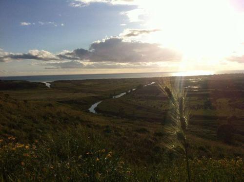 a view of a field with a river and the sun at B&B Eraclea Minoa Mare in Eraclea Minoa