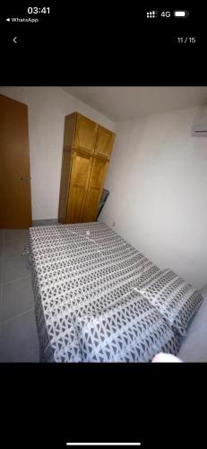 a bedroom with a bed and a wooden cabinet at Apartamento MRV perto da musiva in Várzea Grande