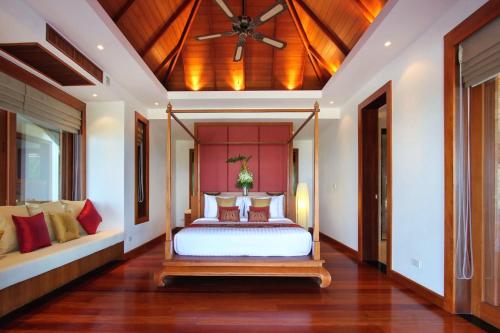 a bedroom with a bed and a ceiling fan at Seaview Villa at Surin Beach in Thalang