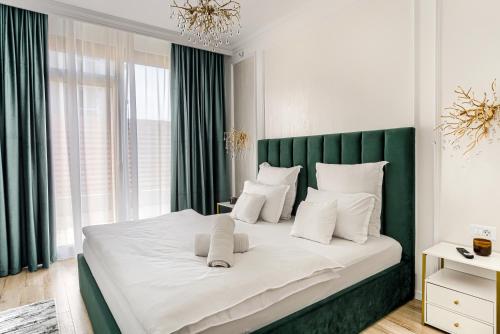 a bedroom with a large bed with a green headboard at Sika Imperial Garden Apartment - cazare Arad - self check-in in Arad