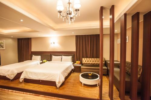 a hotel room with two beds and a chandelier at Pungnam Tourist Hotel in Jeonju