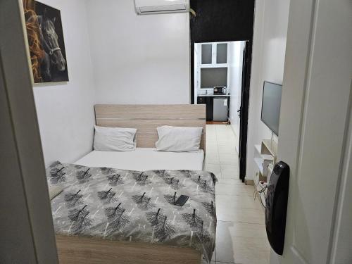 um pequeno quarto com 2 camas e uma televisão em Appartement haut standing a la cité attaya em Dakar