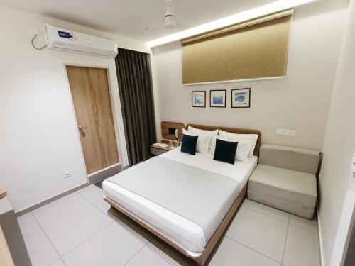 a hotel room with a bed and a couch at Hotel Kant by GoHotels - Best Hotel Near Shree Dwarkadhish Temple in Dwarka