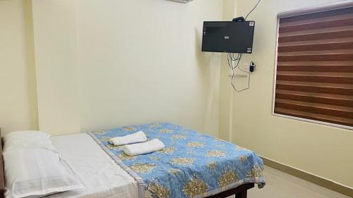 a bedroom with a bed with towels on it at Manu's Home Stay in Malayāttūr