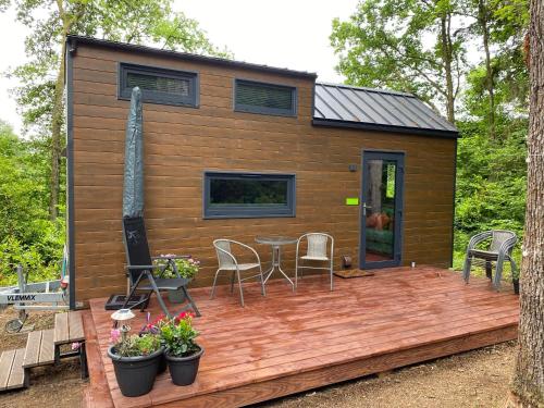 a tiny house with a deck with a table and chairs at La Tiny House de Nanou in Rochefort