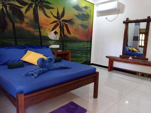 a bedroom with a bed with a blue teddy bear on it at Lobster Inn in Trincomalee