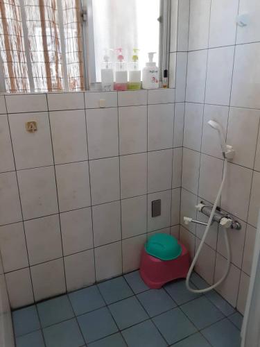a bathroom with a toilet with a green seat at Minshuku Tantawan -SEVEN Hotels and Resorts- in Motobu