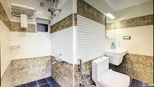 a bathroom with a toilet and a sink at PRIME SUITES in Bengaluru