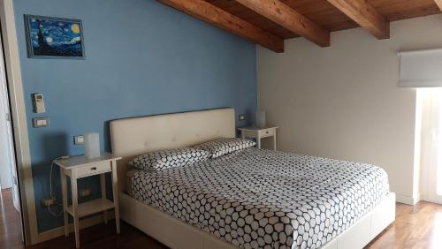 デセンツァーノ・デル・ガルダにあるVilla Paolaの青い壁のベッドルーム1室(ベッド1台付)