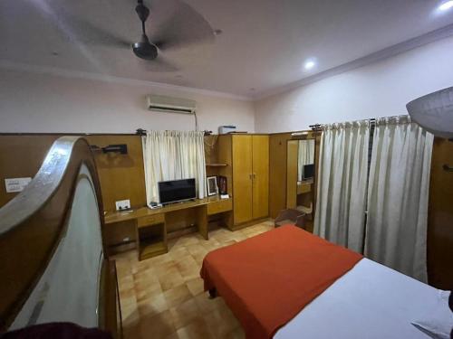 a hotel room with a bed and a tv and a room at Varal Mane in Bangalore