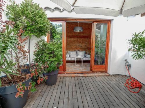 patio con piante in vaso su una terrazza in legno di Beach Villa Aralinn by Hello Homes Sitges a Sitges