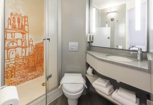 a bathroom with a toilet and a sink and a mirror at B&B HOTEL Albi in Albi