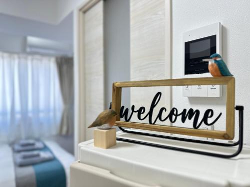 a welcome sign on a dresser in a bedroom at nestay miriz tokyo ikebukuro in Tokyo