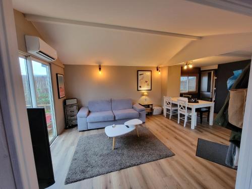 un salon avec un canapé et une table dans l'établissement Chalet 47m2 climatisé, piscine,linge fourni, à Gujan-Mestras