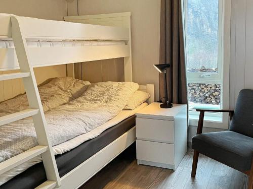 a bedroom with a bunk bed with a desk and a chair at 10 person holiday home in Lindesnes in Spangereid