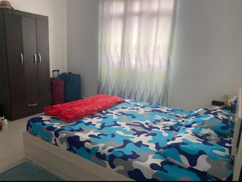 a bedroom with a bed with a blue and white comforter at A 7 Villa in Quartier Militaire