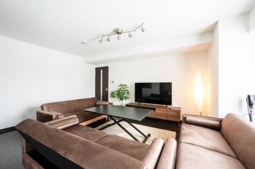 a living room with a couch and a table at Shizuk +O Stay 2 in Kita-sanjō