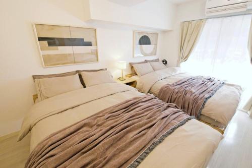 a bedroom with two beds and a window at ダイトービル305 in Tokyo