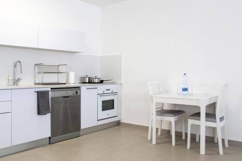 a kitchen with a table and a sink and a stove at Luxury Penthouse #46 By Hashdera Eilat in Eilat