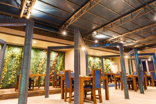 a restaurant with tables and chairs and plants on the walls at XYZ Private Spa and Seaside Resort in Shirahama