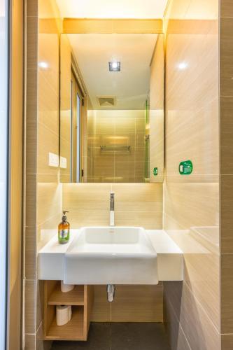 a bathroom with a white sink and a mirror at Greystone 99 Suites in Melaka