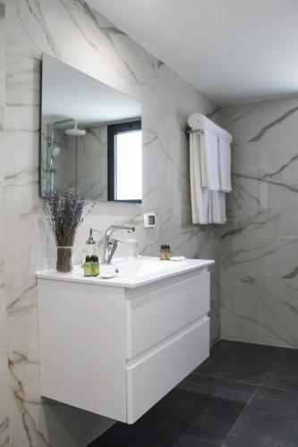 a white bathroom with a sink and a mirror at Luxury Penthouse #46 By Hashdera Eilat in Eilat