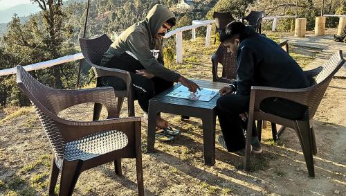 two men sitting at a table playing a game at Ghumakkad Stay in Jageshwar