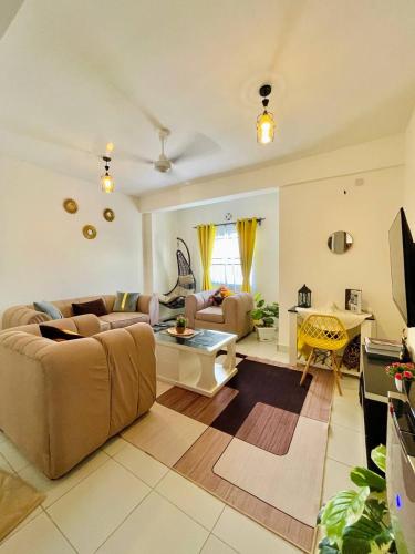 een woonkamer met een bank en een tafel bij Ample home 2 bedroom apartment in Mombasa