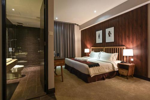 a hotel room with a bed and a bathroom at 1825 Gallery Hotel in Melaka