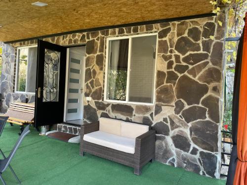 a porch with a chair and a stone house at Borjomi Veranda in Borjomi