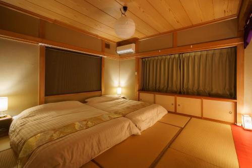 1 dormitorio con cama grande y ventana grande en １組限定　家族連れ歓迎　松本城徒歩15分　無料駐車場2台有 en Koyanagichō
