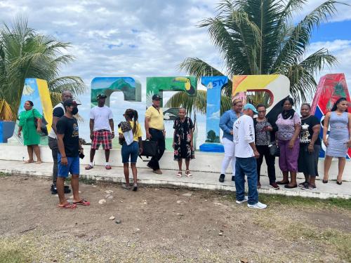 a group of people standing in front of a sign at Los Guacamayos La Ceiba in La Ceiba