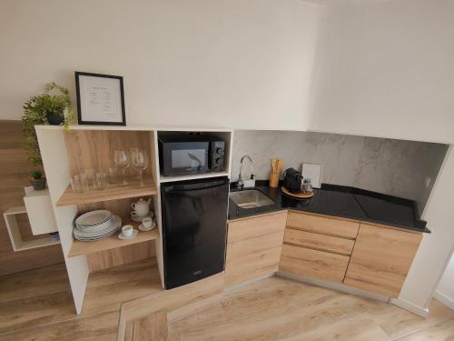 a kitchen with a black refrigerator and a microwave at Pineda apartamento de playa in La Pineda