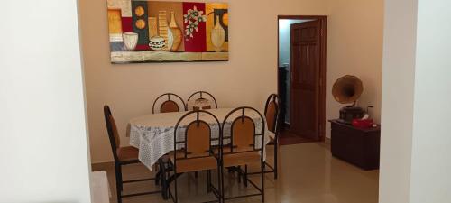 uma sala de jantar com mesa e cadeiras em Suburbs Holiday Home em Dabolim