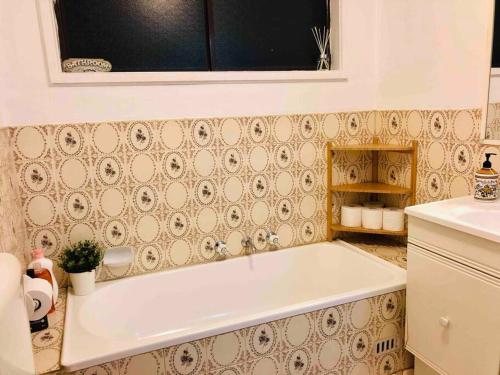 a bath tub in a bathroom with a tiled wall at Penrith Relaxing Beauty 3BR Entire House Sleep 8 in Penrith