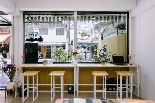 a bar with stools in front of a window at LD1.House Private Room,Thapae Gate, Chiang Mai Old city in Chiang Mai
