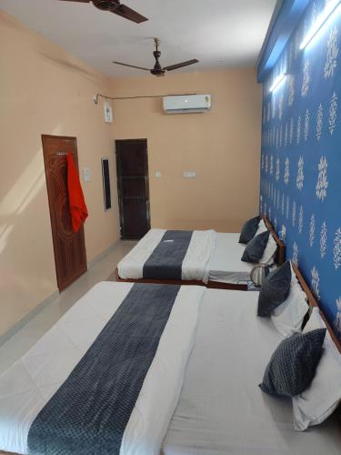 a bedroom with two beds and a blue wall at Hotel shivay in Varanasi