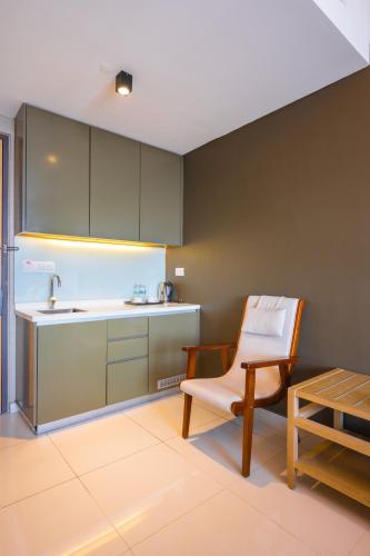 a kitchen with a chair and a sink and a table at Greystone 99 Suites in Melaka