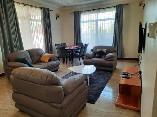 a living room with a couch and a table at Ellyz Home Stay in Moshi