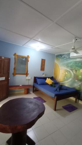 a living room with a blue couch and a table at Lobster Inn in Trincomalee