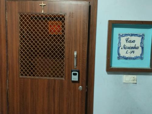 a wooden door with a sign on it in a room at A Private Room With Terrace in Ahmedabad