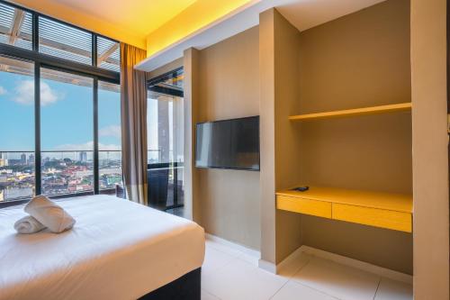 a bedroom with a bed and a tv and a window at Greystone 99 Suites in Melaka